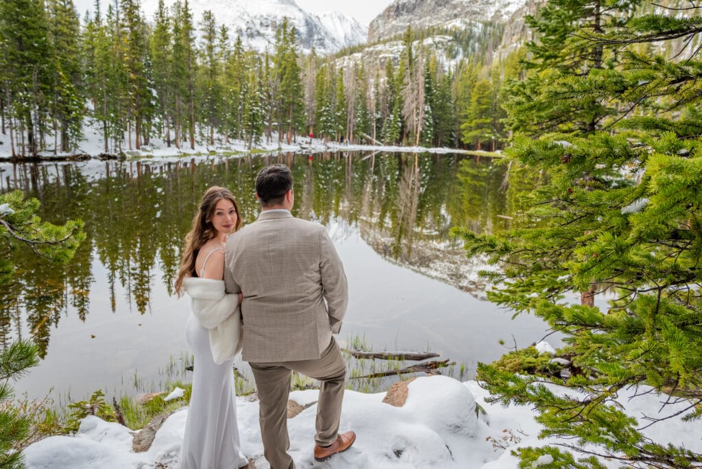 What is the Best Time of Year to Elope in Colorado? Couple stand before and Alpine lake in wedding attire.