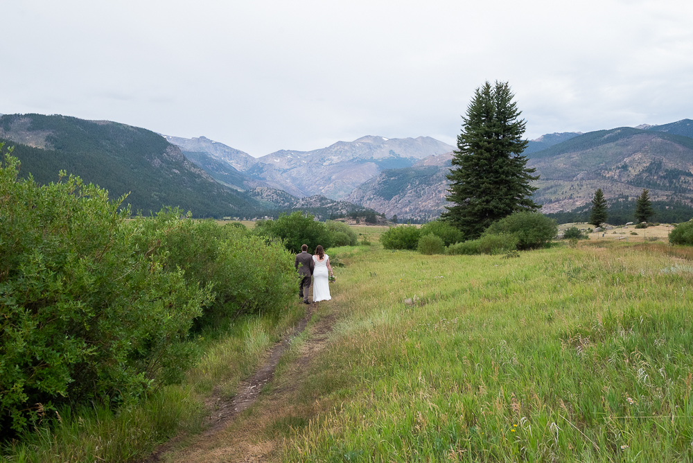 Last Minute Elopement in estes park, CO. Newlywed Couple walks down trail in moraine park in RMNP.