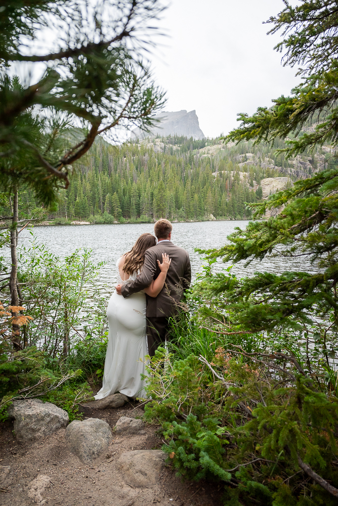 Last Minute Elopement in estes park, CO. Newlywed Couple stands at Bear Lake and looks over the scenery.