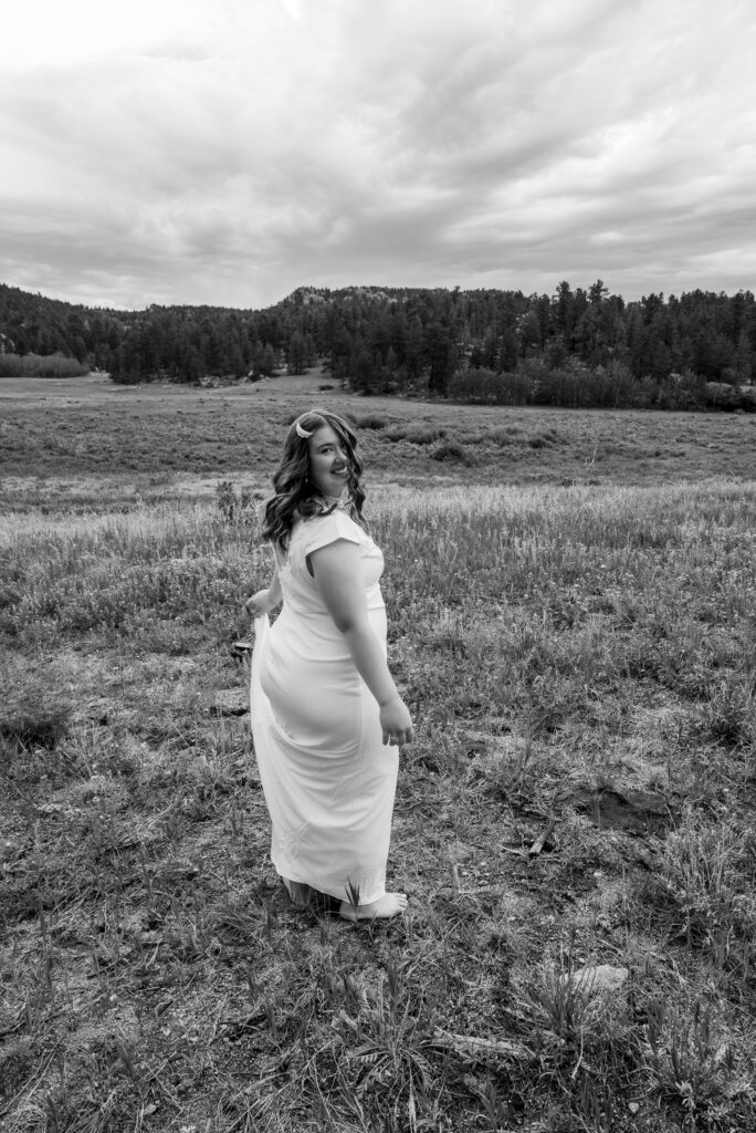 last minute elopement in Estes Park. Bride spins with her dress in the meadow where she got married.